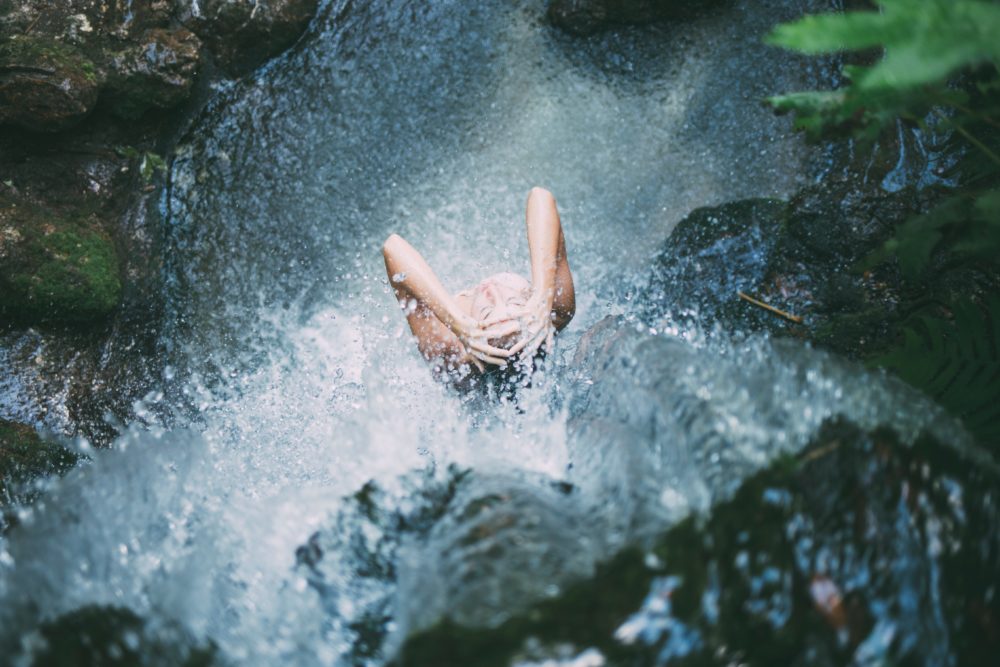 Girl Bathing In A Waterfall